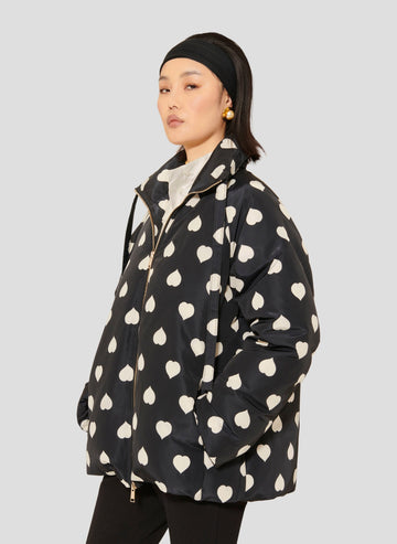Tara Jarmon model wearing black down jacket with white hearts.