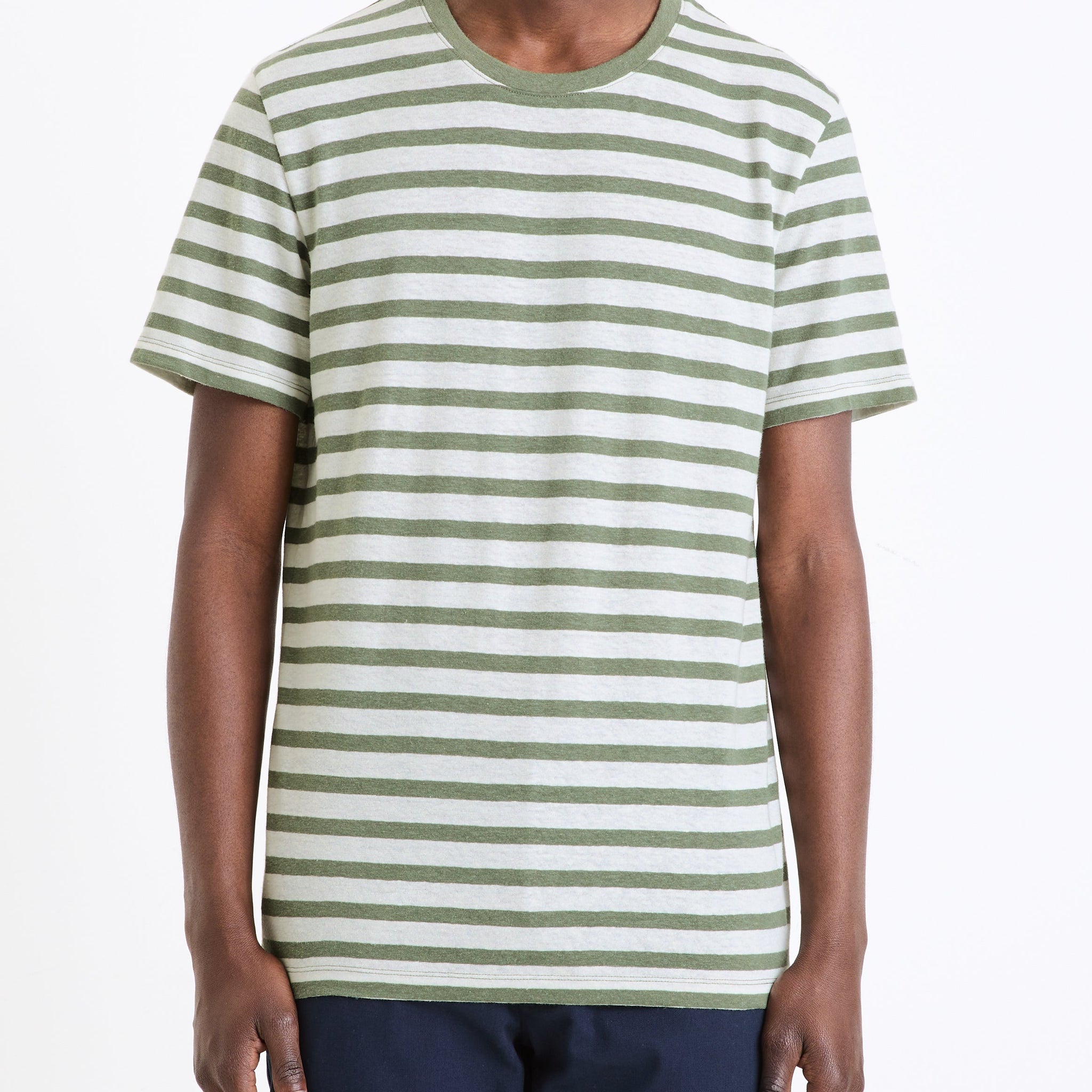 A man wearing a green and white striped short-sleeved t-shirt.