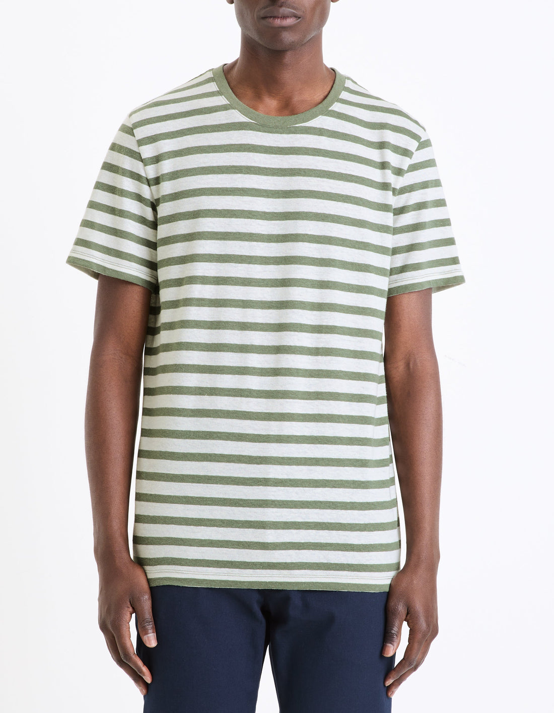 A man wearing a green and white striped short-sleeved t-shirt.