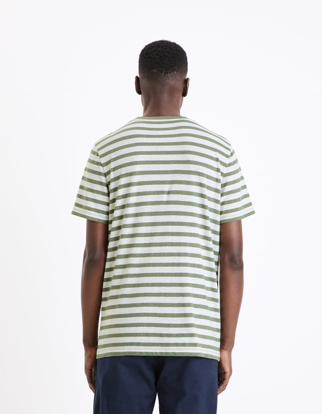 A man wearing a green and white striped short-sleeved t-shirt.