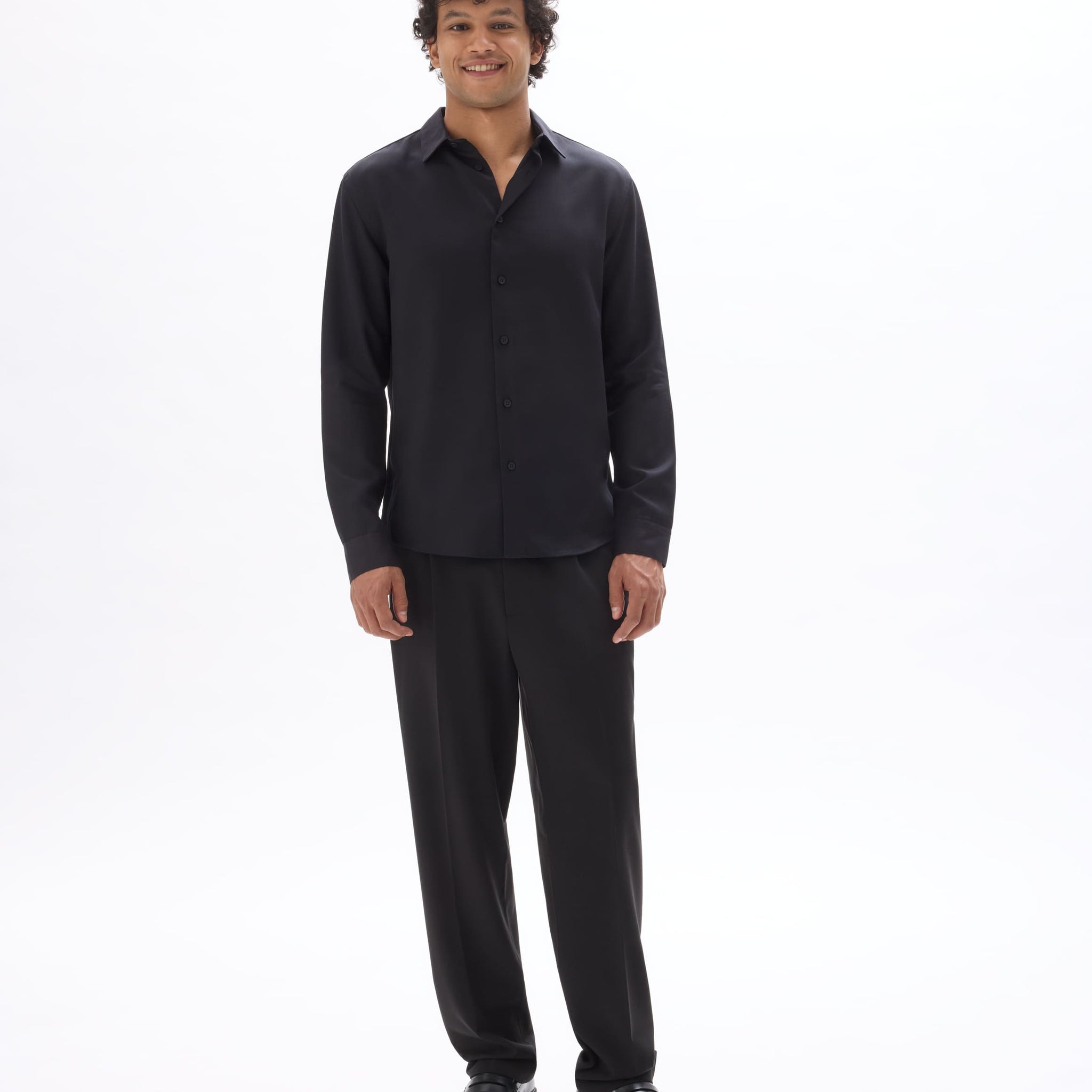 Man wearing a black shirt and pants on a white background