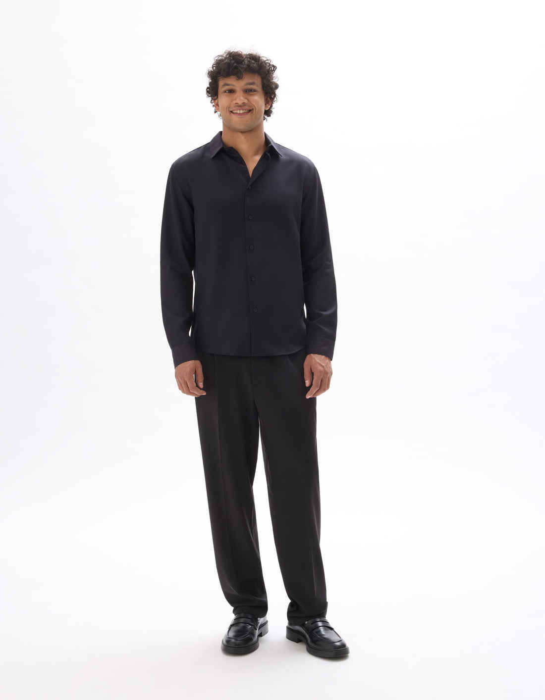 Man wearing a black shirt and pants on a white background