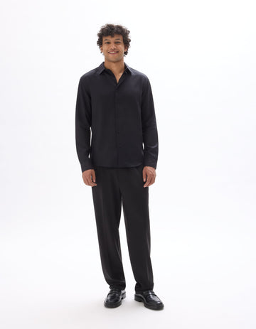 Man wearing a black shirt and pants on a white background