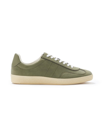 Green sneaker with white sole on a white background
