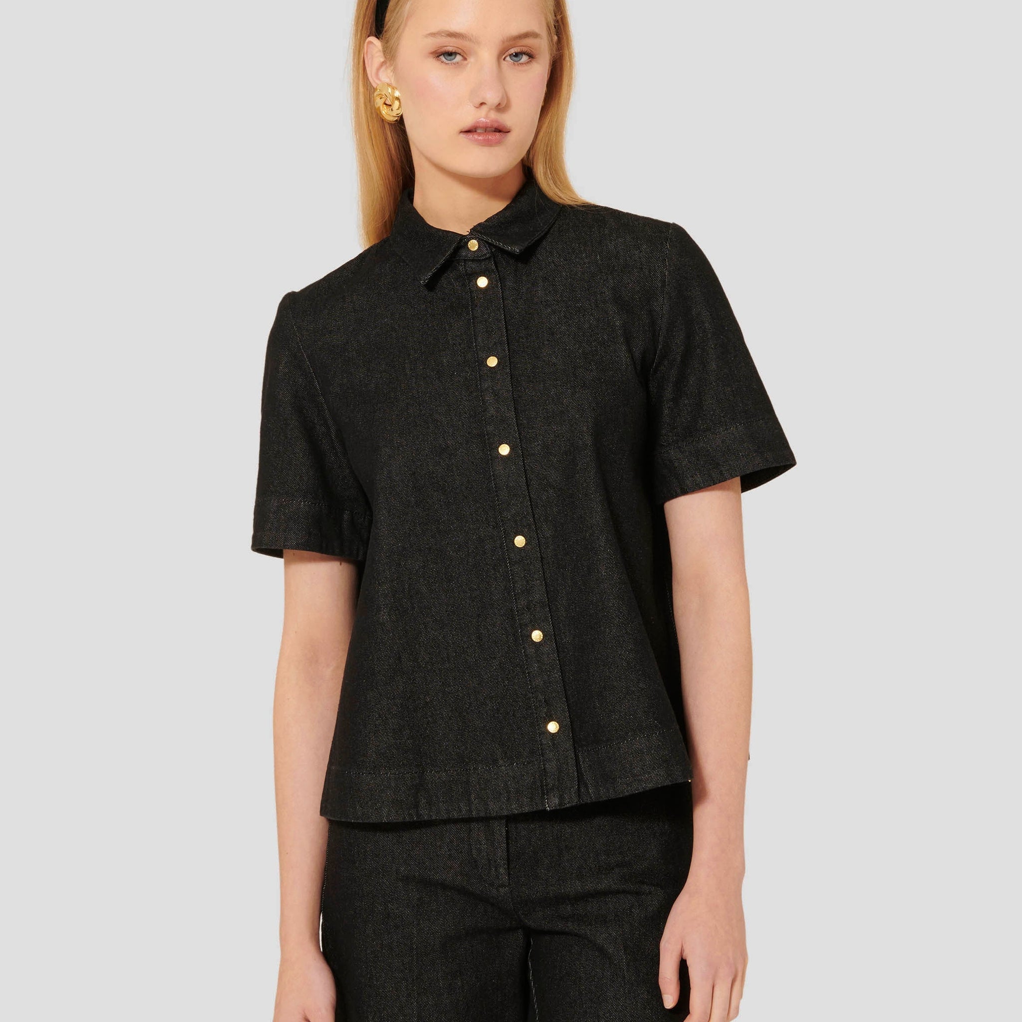 Model wearing Tara Jarmon black denim short sleeves shirt. 