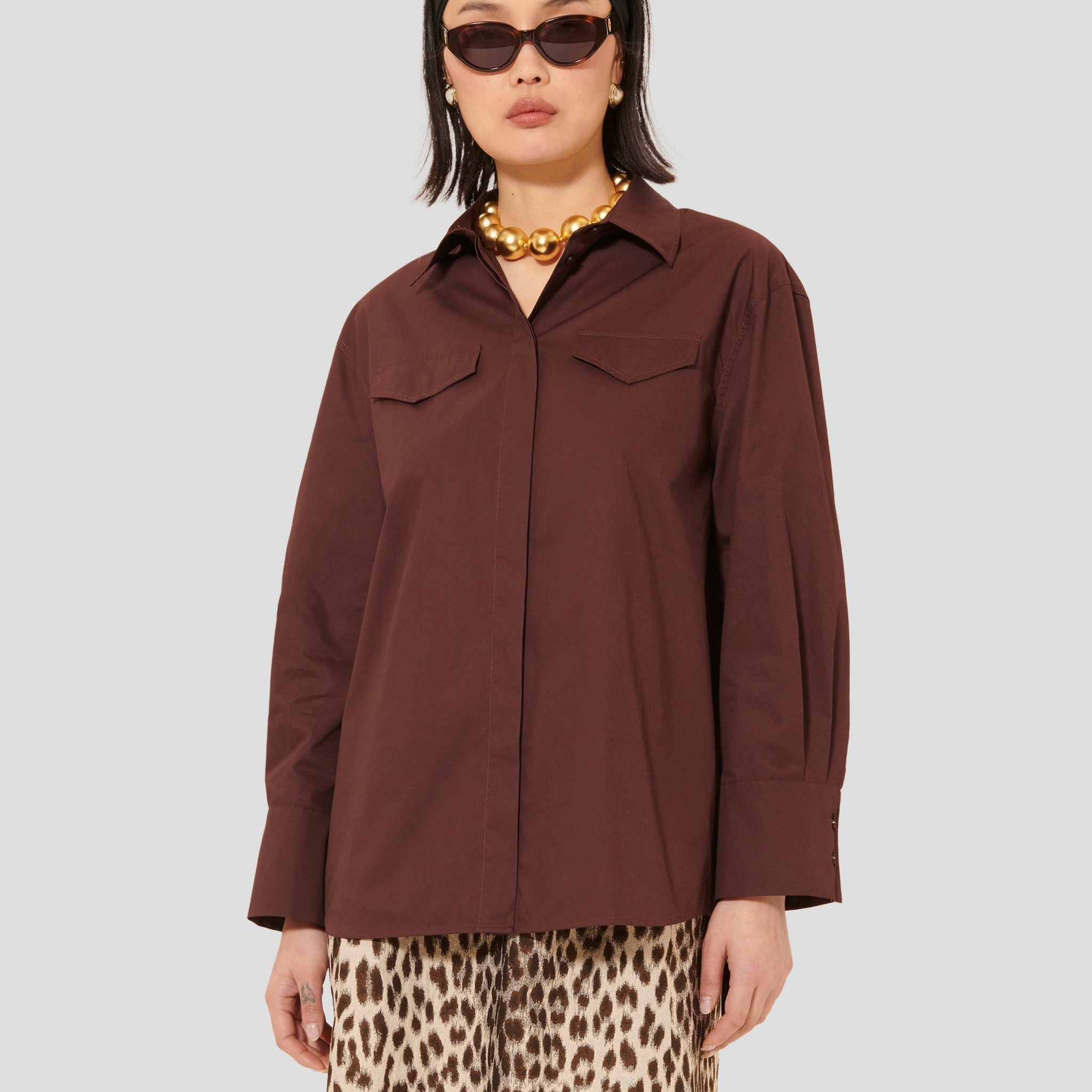 Model wearing Tara Jarmon cotton burgundy poplin shirt.