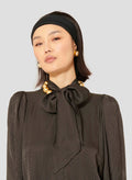 Model wearing Tara Jarmon black polka dot shirt with long puffed sleeves.