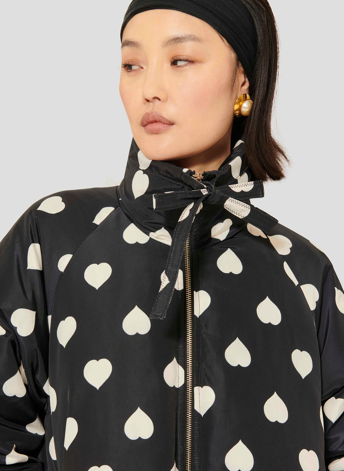 Tara Jarmon model wearing black down jacket with white hearts.