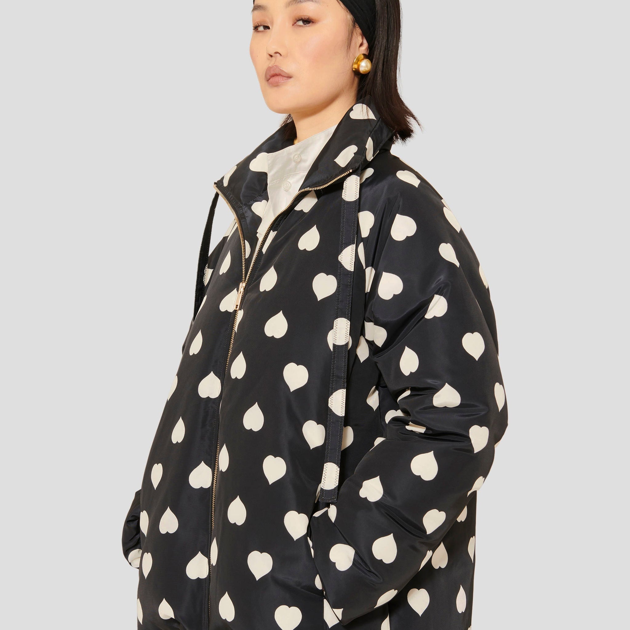 Tara Jarmon model wearing black down jacket with white hearts.