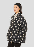 Tara Jarmon model wearing black down jacket with white hearts.