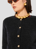 Blue cardigan with round collar, long sleeves, buttoned cuffs and a short straight cut.