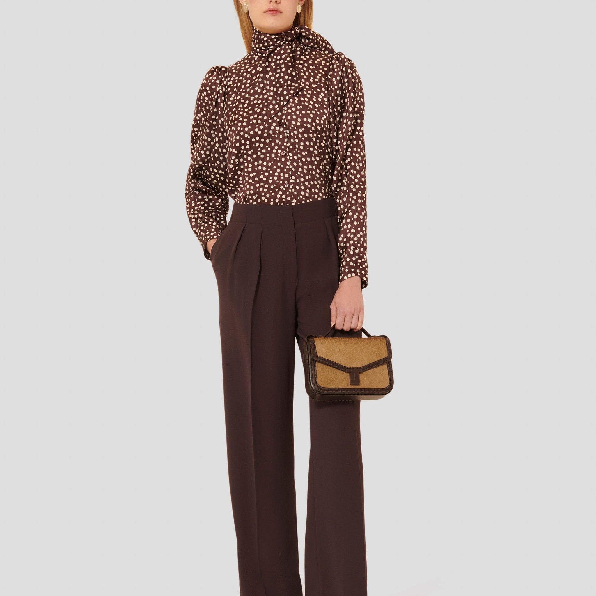 Model wearing Tara Jarmon brown crepe pants.