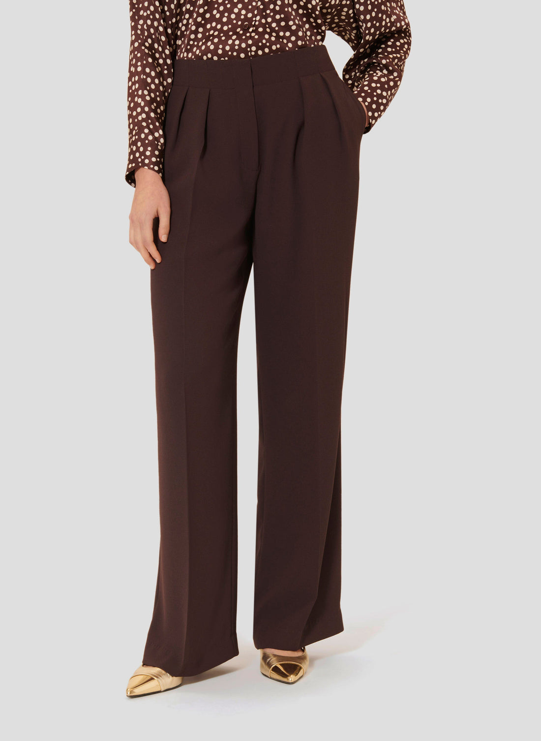 Model wearing Tara Jarmon brown crepe pants.