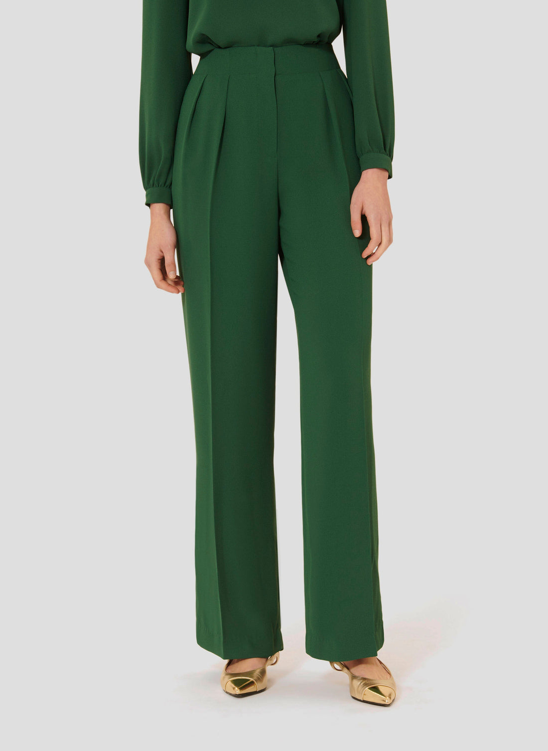Model wearing Tara Jarmon green crepe pants. 