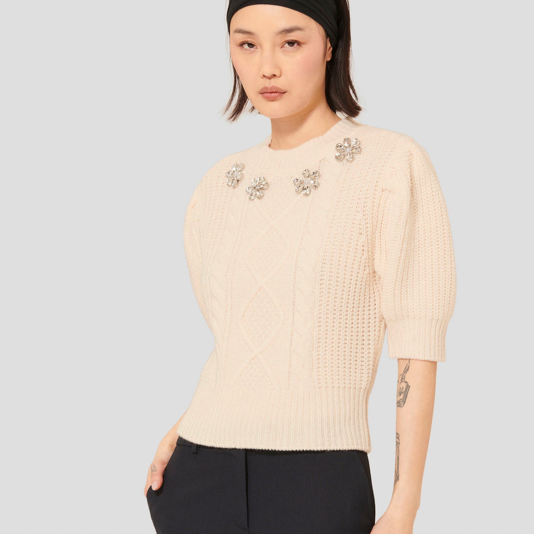 Model wearing Tara Jarmon Women's Off-White Sweater with Embroidered Floral Detail.