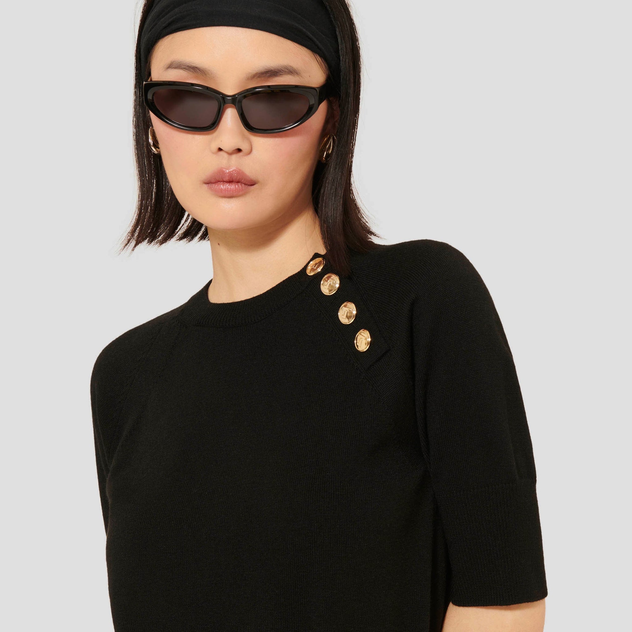 Women's Soft Wool Black Sweater with Round Collar, Short Sleeves, and Gold Buttons.