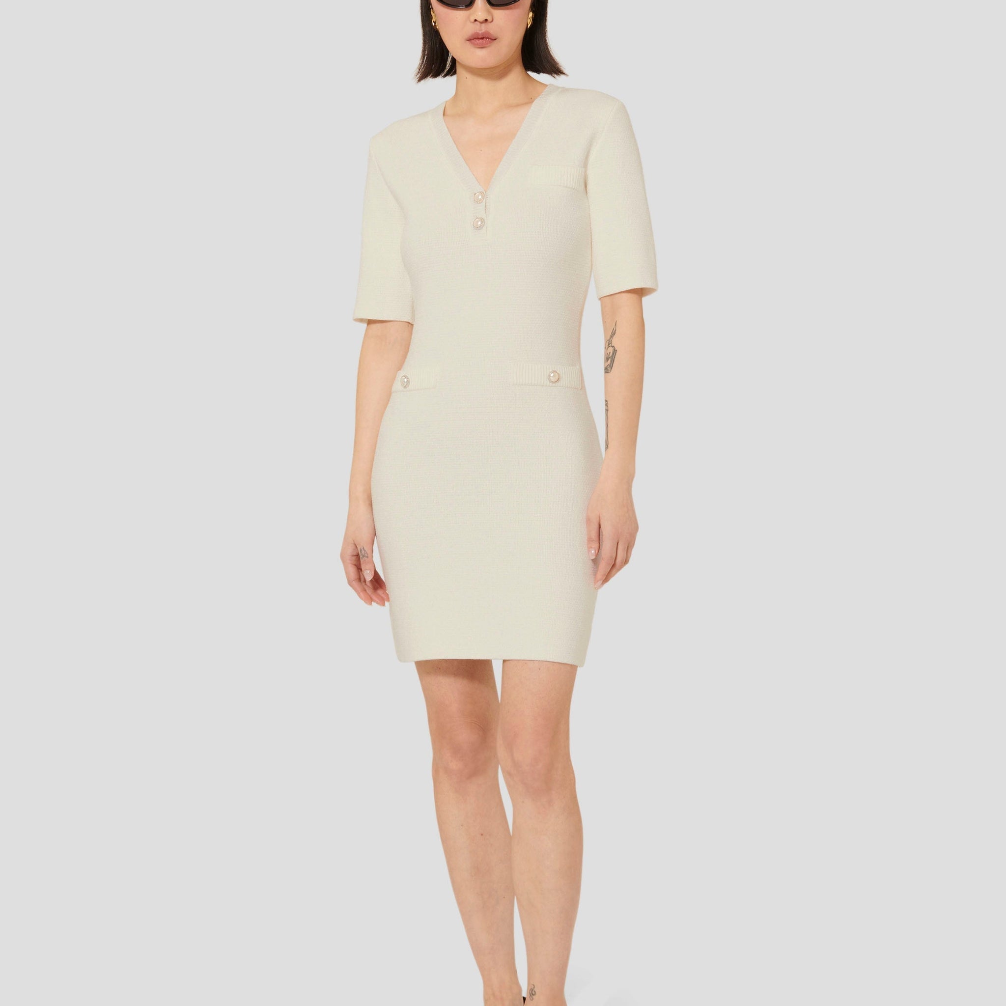 Model wearing Tara Jarmon Ecru Knit Dress with V-Neck and 3/4-length sleeves.