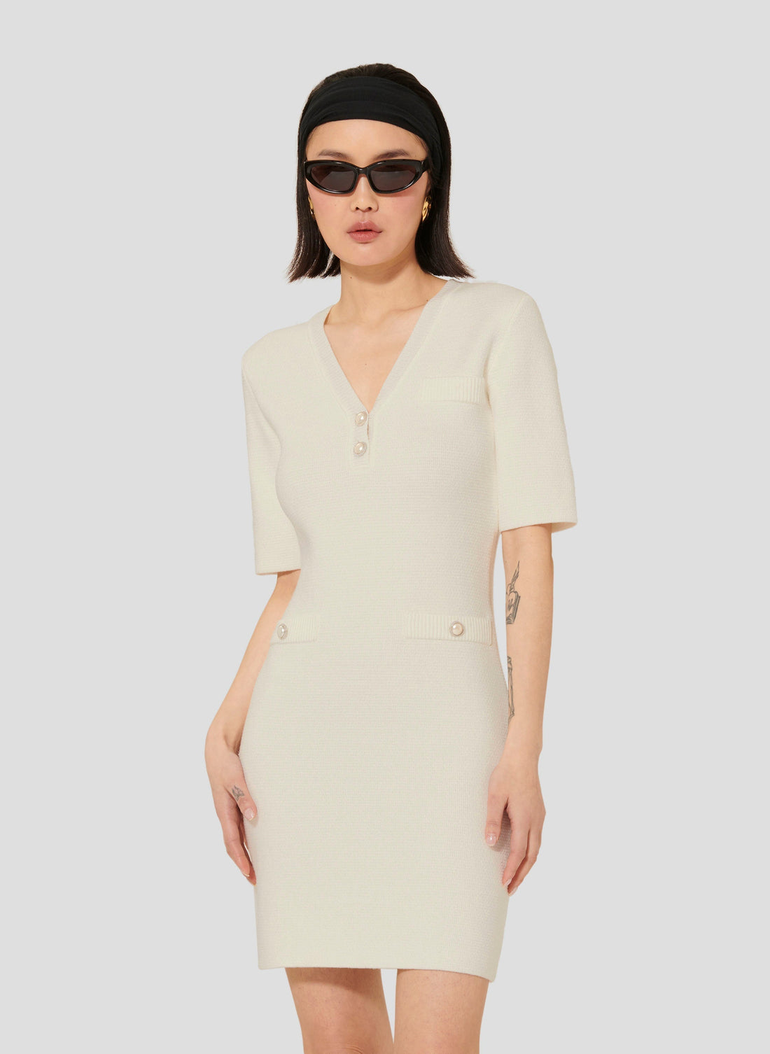 Model wearing Tara Jarmon Ecru Knit Dress with V-Neck and 3/4-length sleeves.