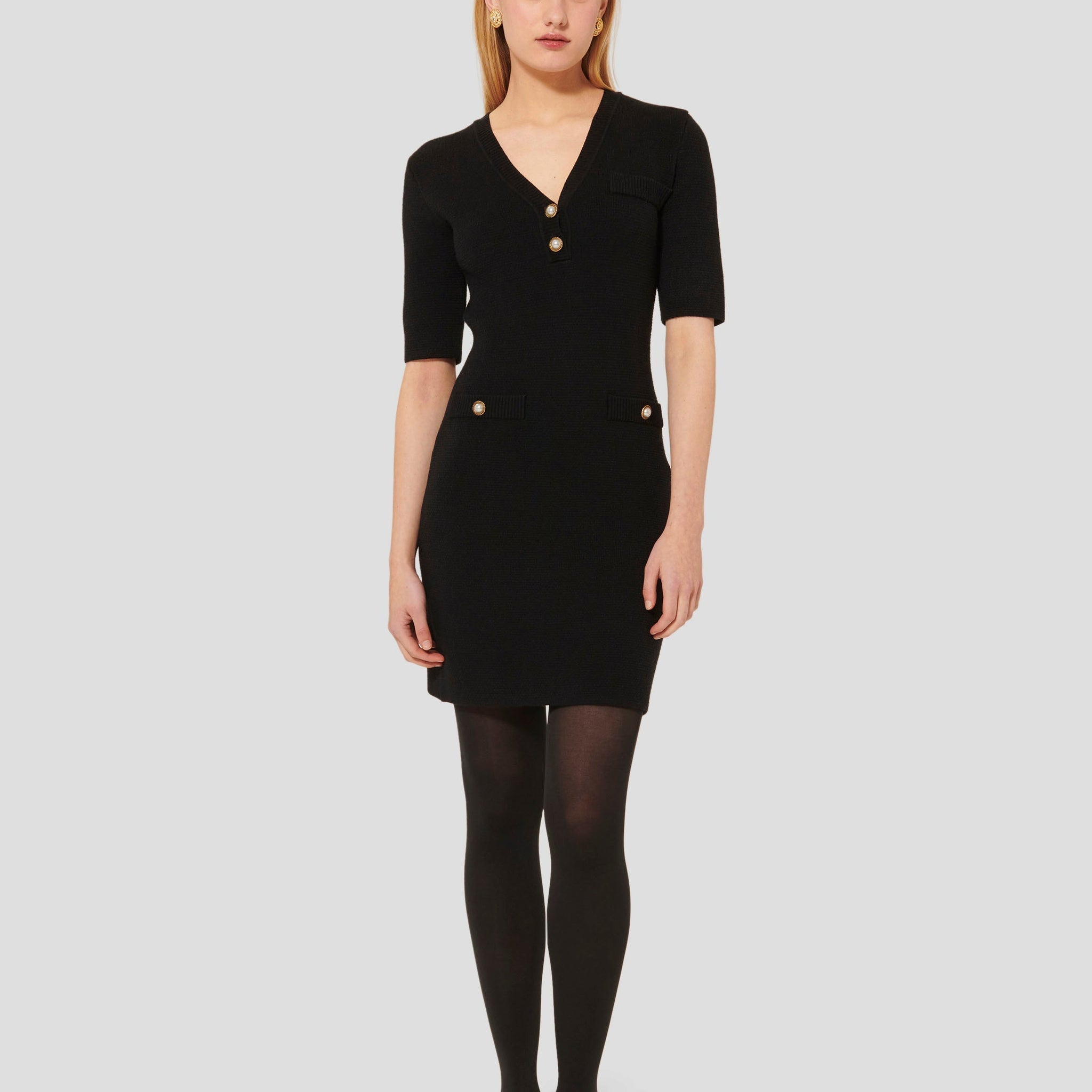 Short black dress with V neckline and 3/4-length sleeves.
