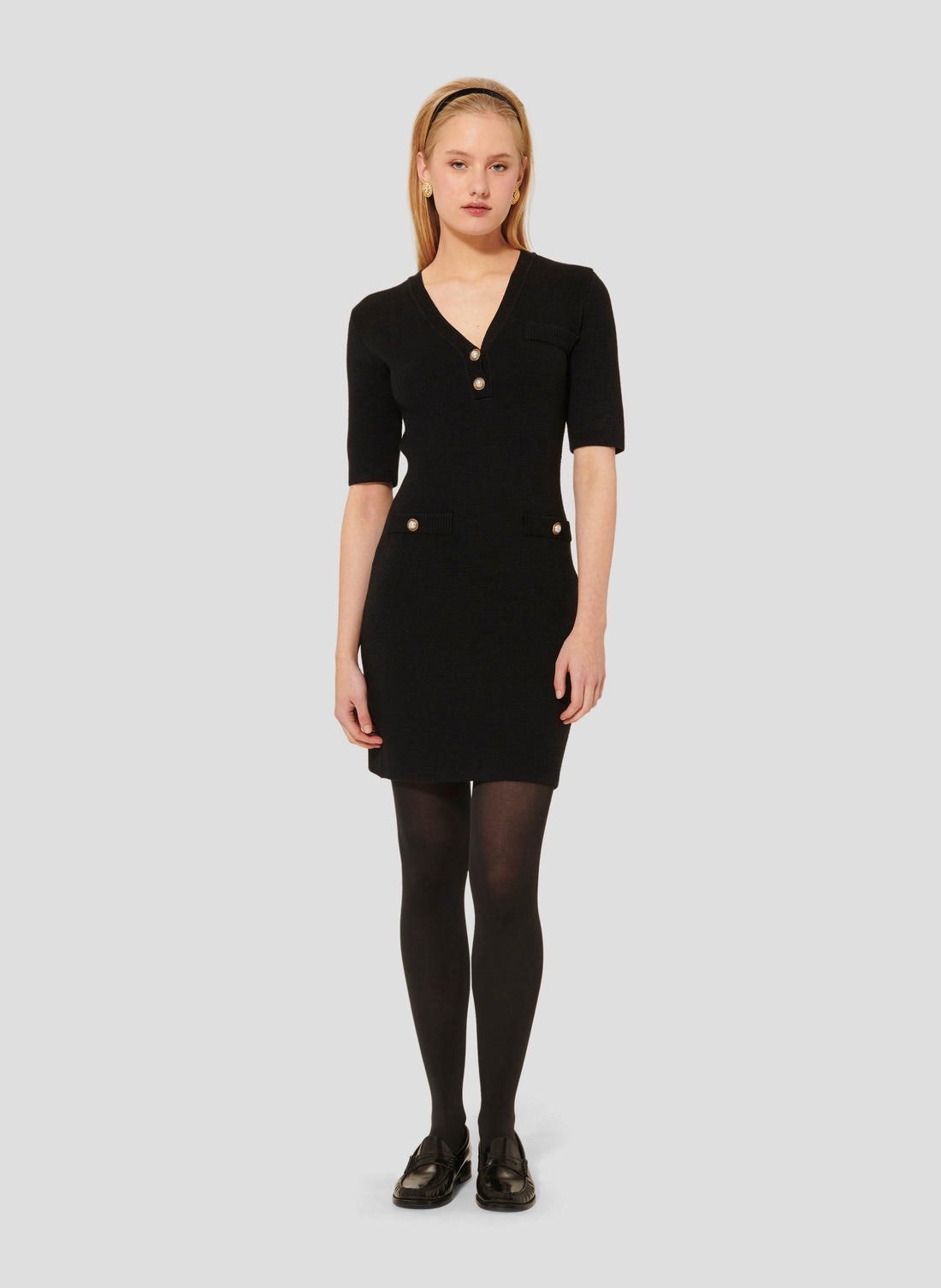 Short black dress with V neckline and 3/4-length sleeves.