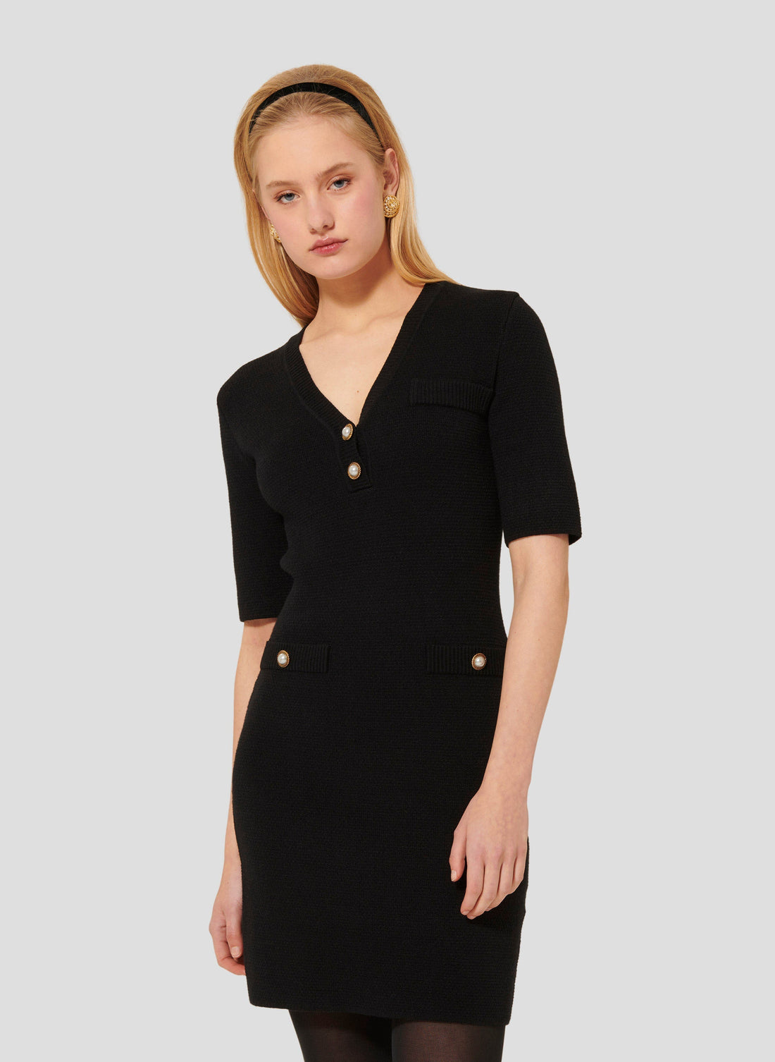Short black dress with V neckline and 3/4-length sleeves.