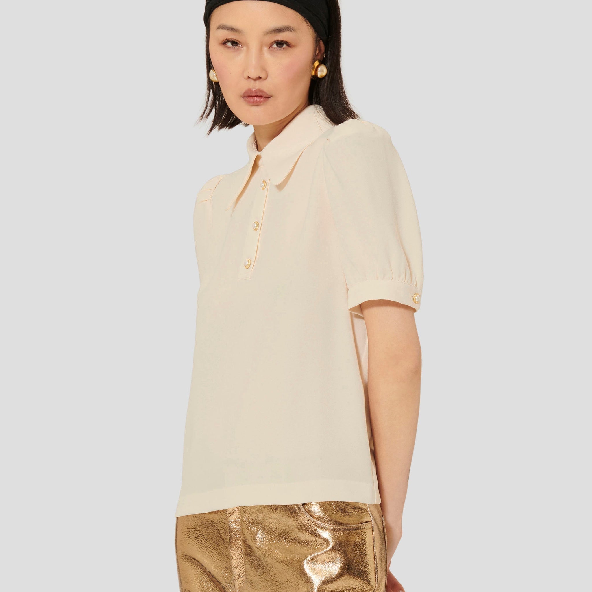 Model wearing Tara Jarmon ecru crepe top with short balloon sleeves. 