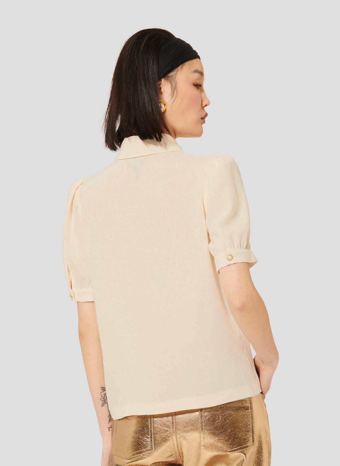 Model wearing Tara Jarmon ecru crepe top with short balloon sleeves. 