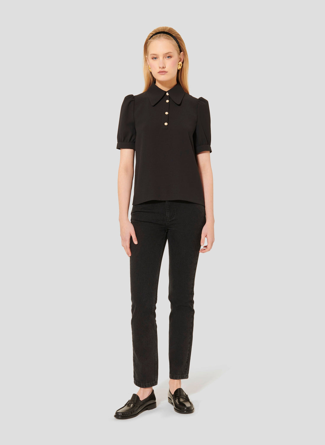 Model wearing Tara Jarmon black crepe top with short balloon sleeves. 