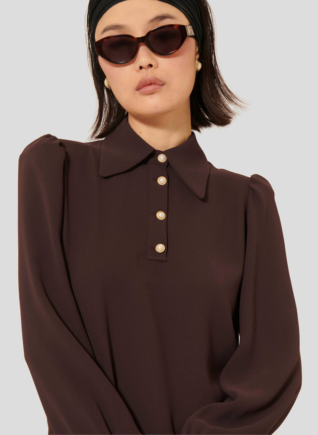 Model wearing Tara Jarmon brown crepe top with long balloon sleeves. 