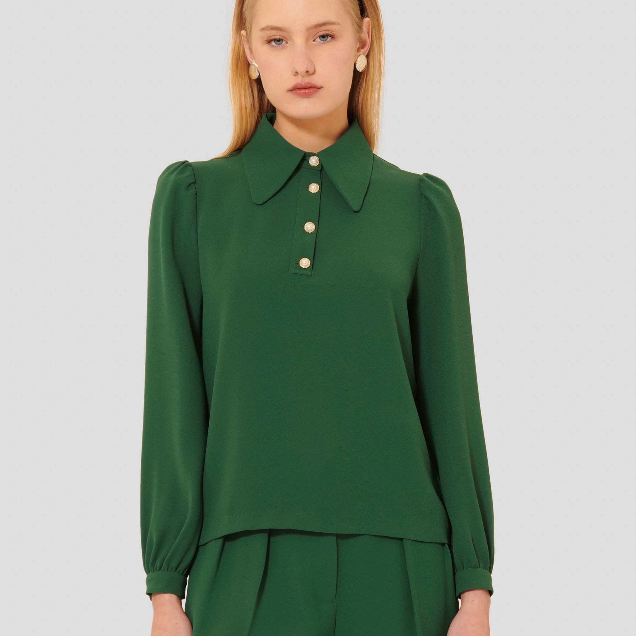 Model wearing Tara Jarmon green crepe top with long balloon sleeves. 