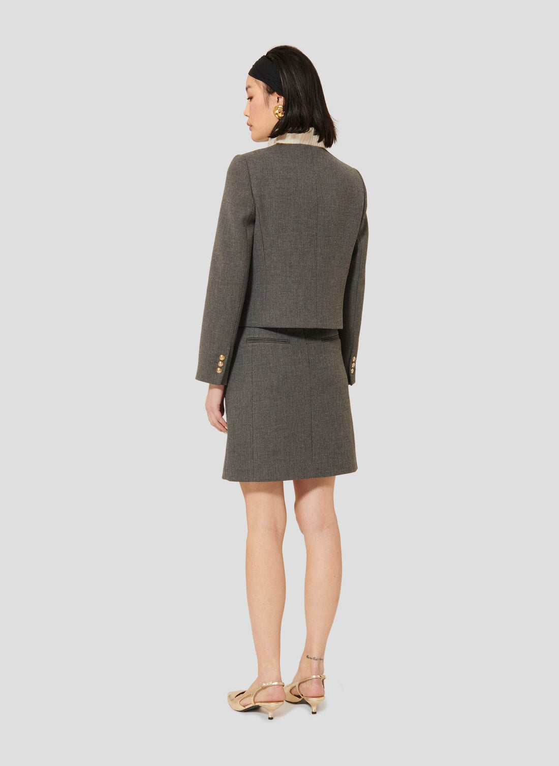 Model wearing Tara Jarmon Grey Canvas Jacket with Round Neckline and Button Closure.