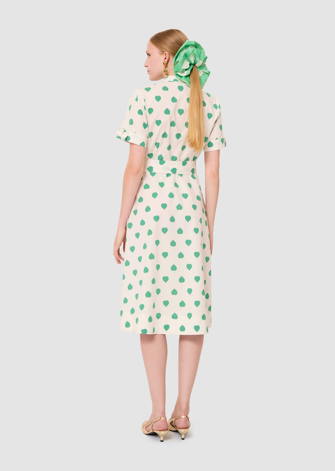 Woman wearing Ricochet green hearts print dress from Tara Jarmon Lebanon on white background