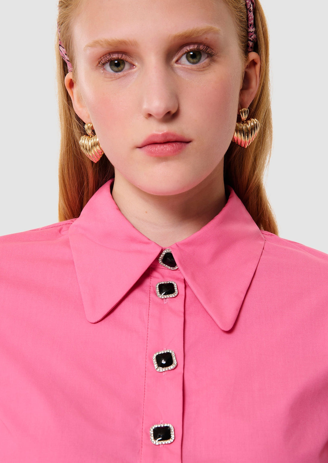 Woman wearing a pink blouse and beige pants on a white background