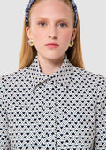 Person wearing a patterned shirt with a plain background