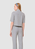 Back view of a Woman wearing a patterned outfit on a plain background